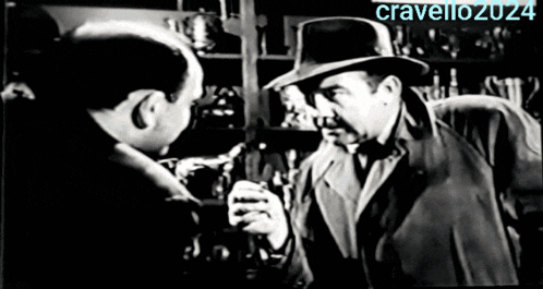 a man in a fedora is talking to another man in a black and white photo that says cravello2024