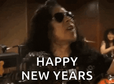 a man in a black shirt is holding a bottle in his hand and says `` happy new year '' .