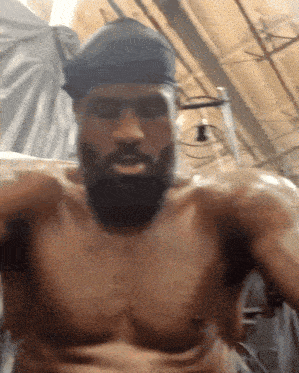 a shirtless man with a beard is wearing a headband
