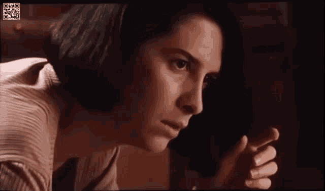 a close up of a woman 's face in a movie looking at something .