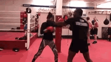 two people are boxing in a boxing ring .