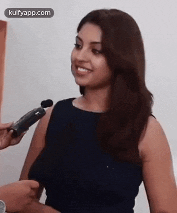 a woman is being interviewed with a microphone .