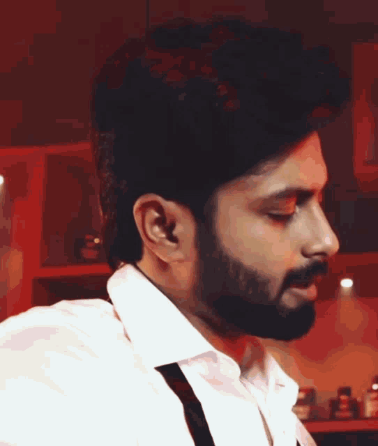 a man with a beard wearing a white shirt and black suspenders