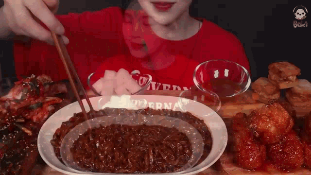 a person in a red shirt is eating a plate of food