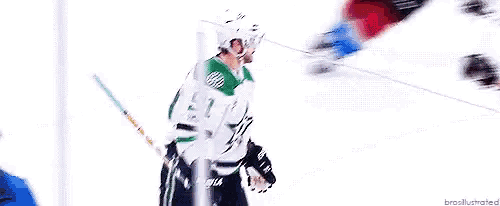 a hockey player is laying on the ice while another player holds a puck .