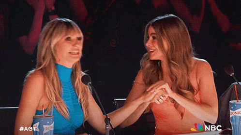 two women shaking hands in front of microphones with nbc written on the bottom right