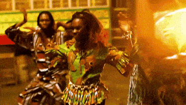 a group of people are dancing in front of a building .