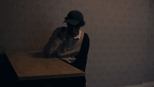 a man stands in a dark room with a microwave and a fridge