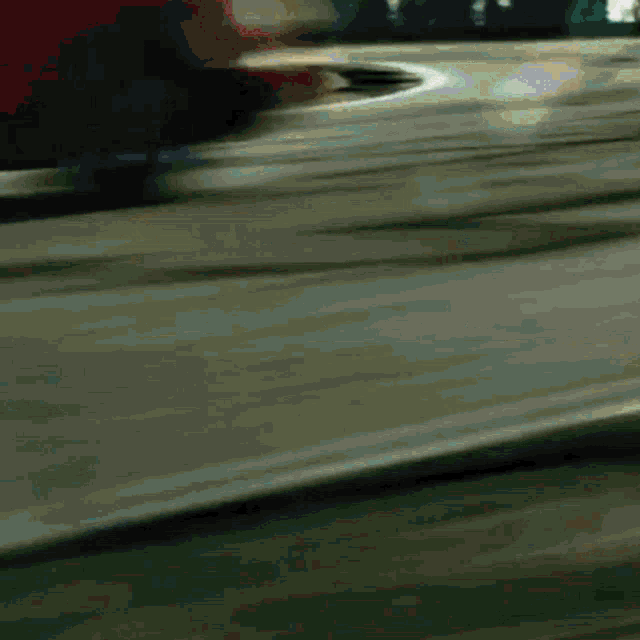 a blurred image of a red car driving down a road