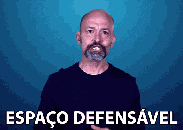 a bald man with a beard is standing in front of a blue background that says espaco defensavel