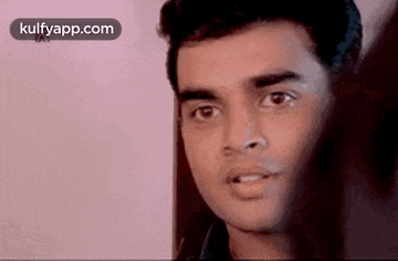 a close up of a man 's face with a pink background .