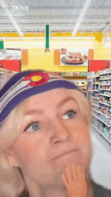a woman wearing a headband with the state of colorado on it is standing in a store .