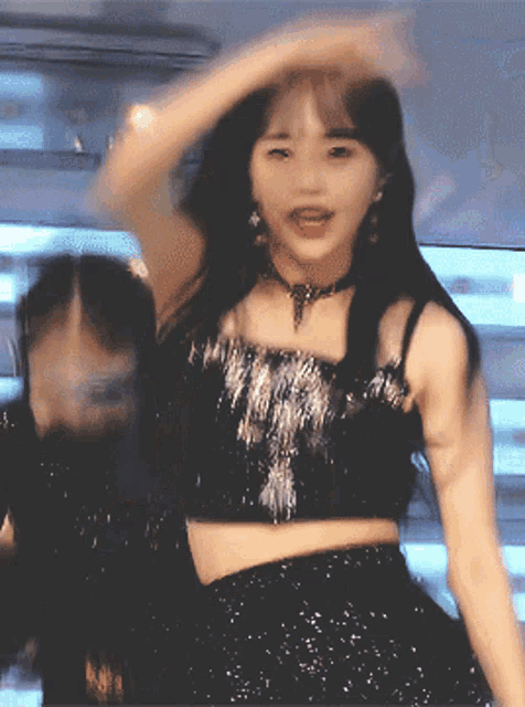 a woman in a black crop top is dancing