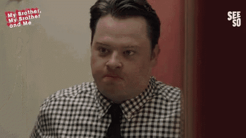 a man with down syndrome is wearing a plaid shirt and tie .