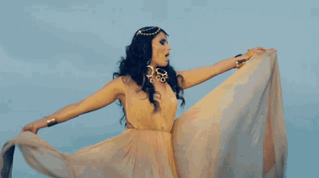 a woman in a long dress is standing with her arms outstretched in the air