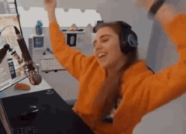 a woman wearing headphones is sitting in front of a computer .