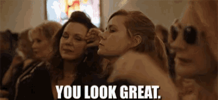 a group of women are sitting in a church and one of them is pointing at another woman .