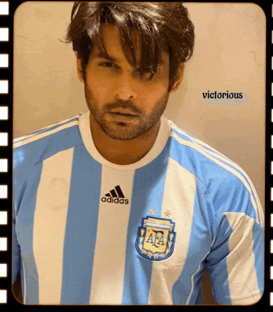 a man is wearing a blue and white adidas jersey