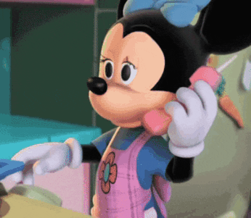 minnie mouse is talking on a pink phone with a flower on her apron