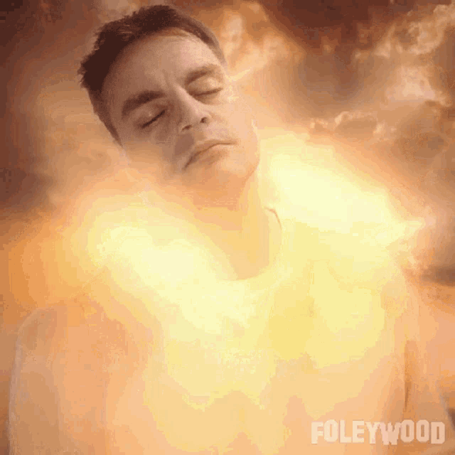 a man with his eyes closed is surrounded by a glowing light and the word foleywood is on the bottom right