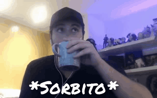 a man is drinking from a blue mug with the word sorbito written on it