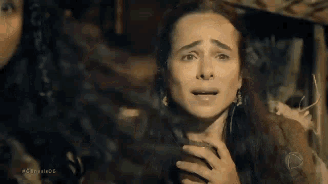 a woman is crying in a dark room while a man looks on .