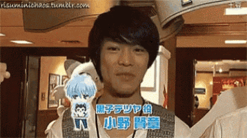 a man with asian writing on his shirt is holding a stuffed animal