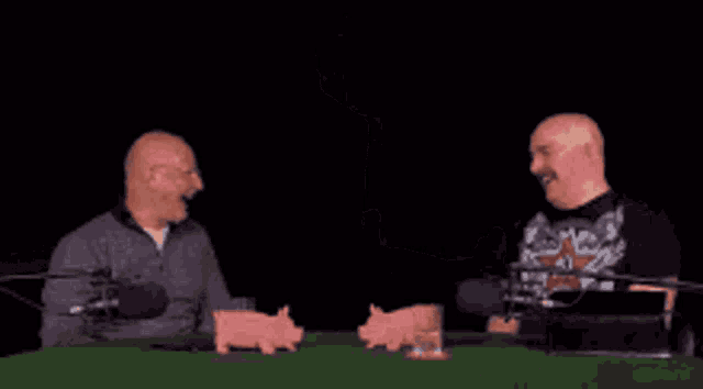 a bald man with glasses is laughing with his mouth open in a close up of his face .