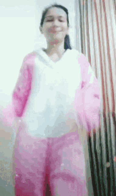 a woman in a pink and white outfit is dancing .