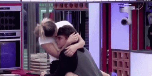 a man is carrying a woman on his back in a room .