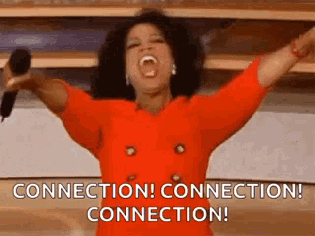 oprah winfrey is holding a microphone with her arms in the air and screaming .