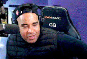 a man wearing headphones sits in a maxnomic gg chair
