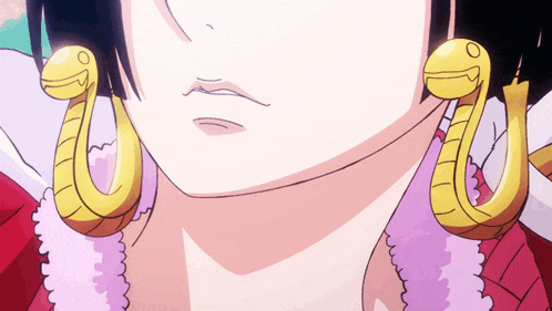 a close up of a woman wearing a pair of snake shaped earrings