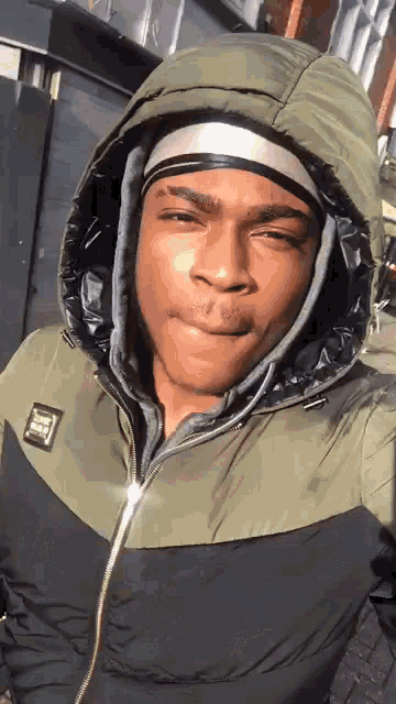 a man wearing a jacket with a hood and a headband on his head