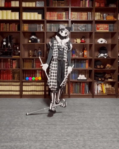 a man in a harlequin costume is standing in front of a bookshelf with a sign that says circus on it