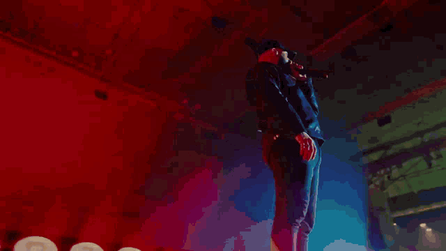 a man singing into a microphone while wearing a hat that says ' i love you '