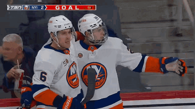 two ice hockey players celebrate a goal during a game between the islanders and the new york islanders
