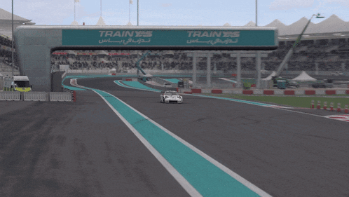 a white race car is driving on a track