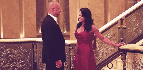 a man and a woman are standing next to each other on a set of stairs .
