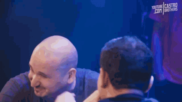two men are talking to each other and one has a youtube castro brothers shirt on