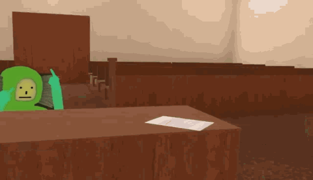 a green cartoon character sitting at a table with a piece of paper on it