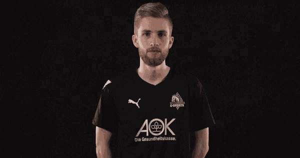 a man wearing a black shirt with aok written on it
