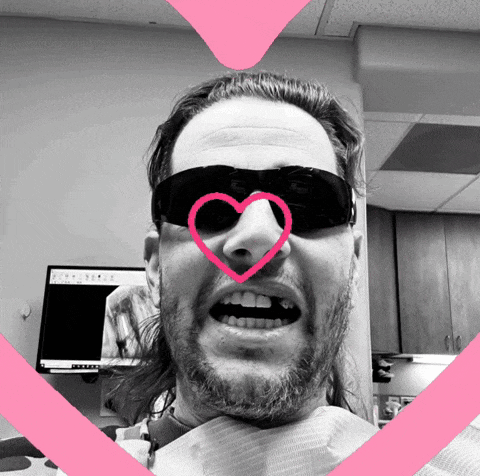a man wearing sunglasses has a heart drawn on his nose