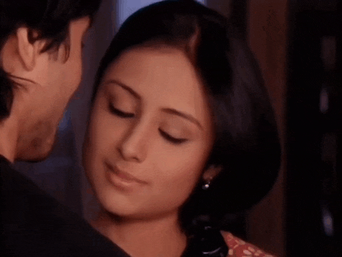 a man and a woman are looking into each other 's eyes and smiling .