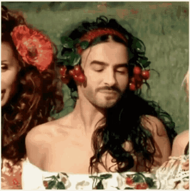 a man with long hair and a flower in his hair is wearing headphones