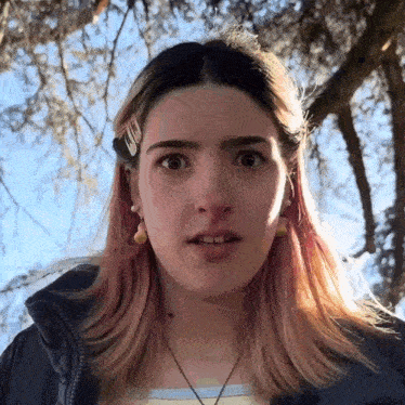 a close up of a girl 's face with a clip in her hair that says ' a ' on it