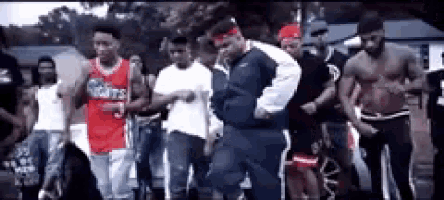 a group of men are dancing in a parking lot and one man is wearing a jersey that says nights