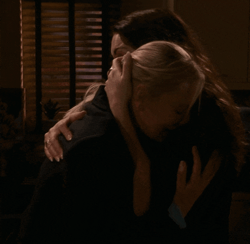 two women hugging each other with one wearing a ring