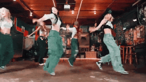 a group of people are dancing in a room with a red ceiling .