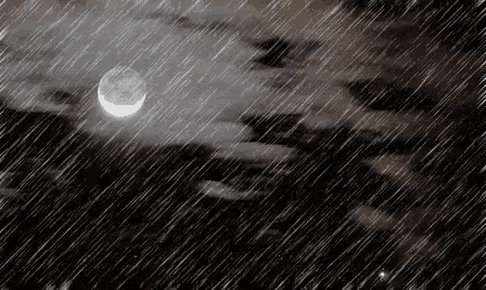 a crescent moon is visible in the night sky while the rain falls .